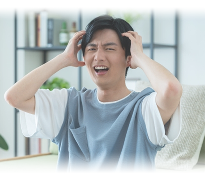 頭を抱えて困っている男性の写真